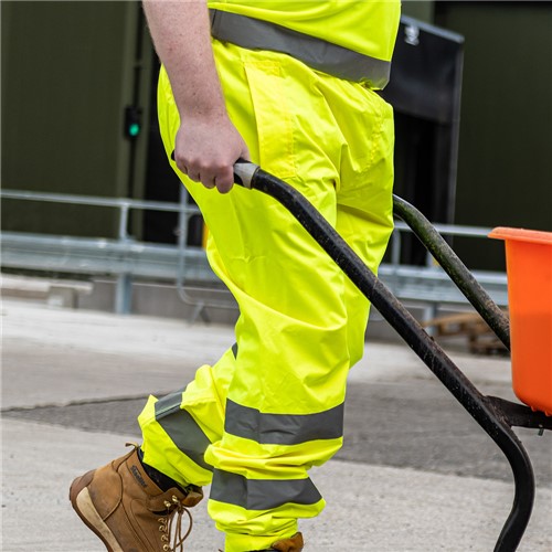 High visibility yellow waterproof over trousers with reflective tape for extra visibility. 100% polyester. • 50mm reflective tape around both legs • Pocket slits to allow east access to wearer&#39;s trouser pockets • Waterproof • Elasticated waistband • 300D PU coated oxford 100% poly fabric &amp; high reflective poly tape
